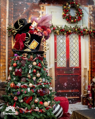 Sapin de Noël décoré et couronne sur une porte rouge.